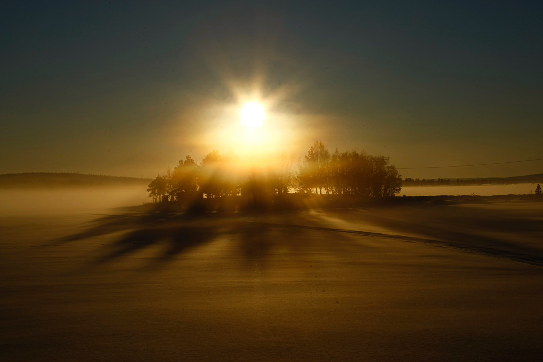 early morning sun behind island